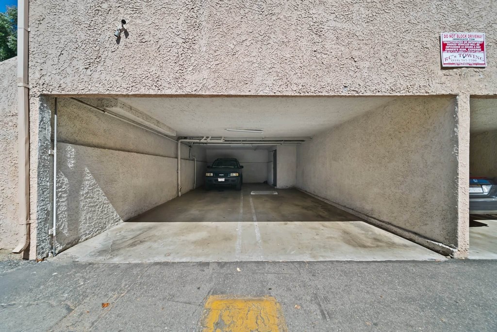 A car is parked in a tunnel under a road.