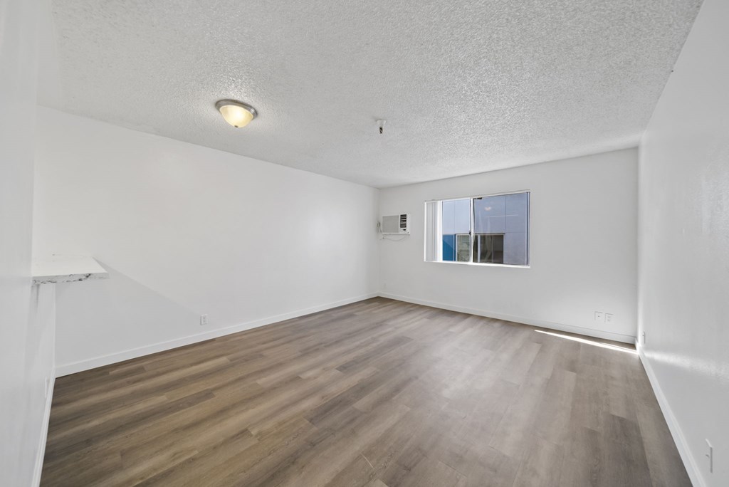 Empty room with wooden floor and white walls.
