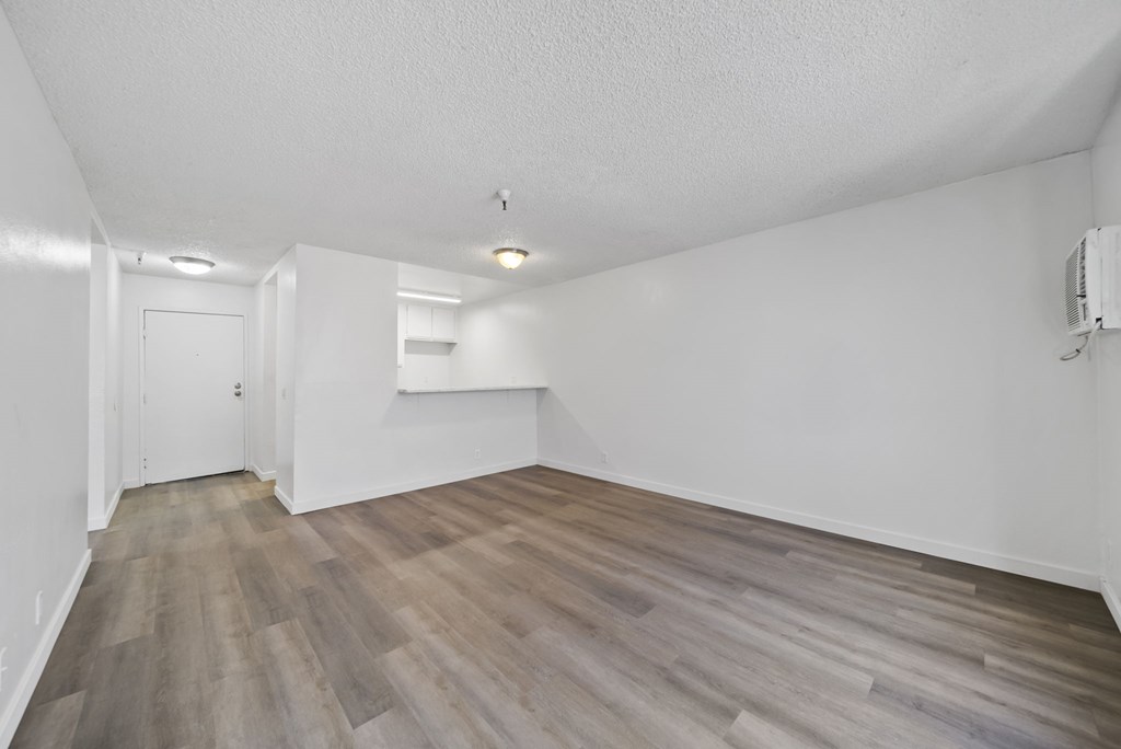 A room with wooden flooring and white walls.