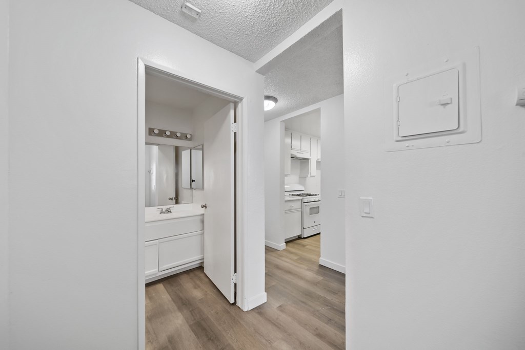A white bathroom with a white vanity and a white door.