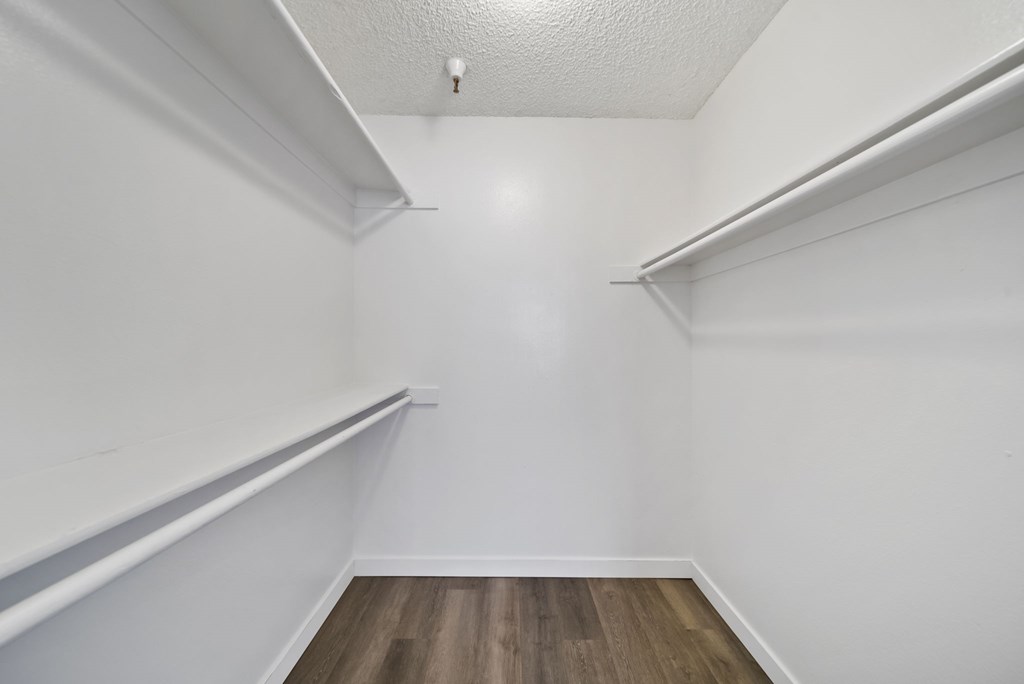 A white room with wood flooring and white walls.