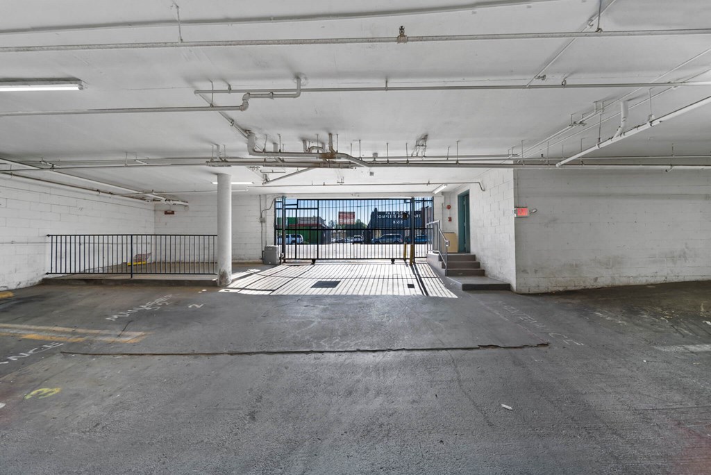 A large, empty parking garage with a view of the outside through a window.
