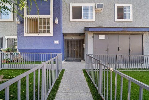 A blue building with a white fence and a grey garage door.