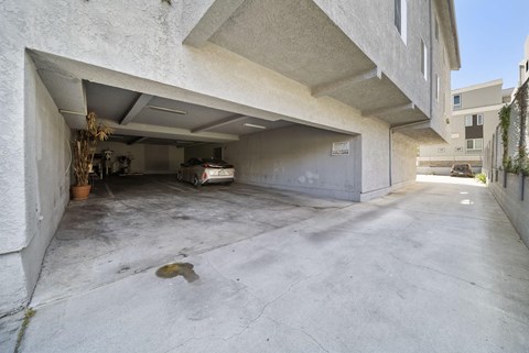 A concrete garage with a white car inside.