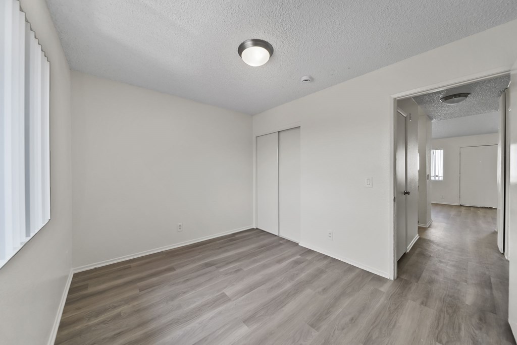 A room with a light on the ceiling and a door on the right.