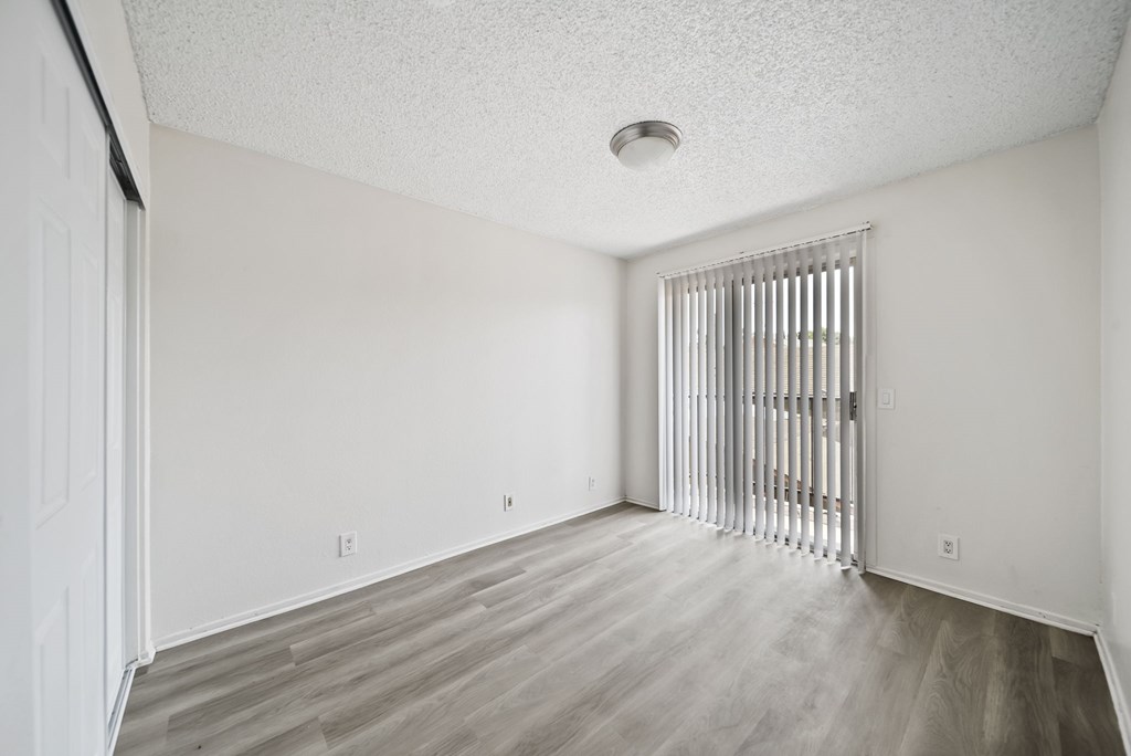 A room with a white ceiling and wooden flooring.