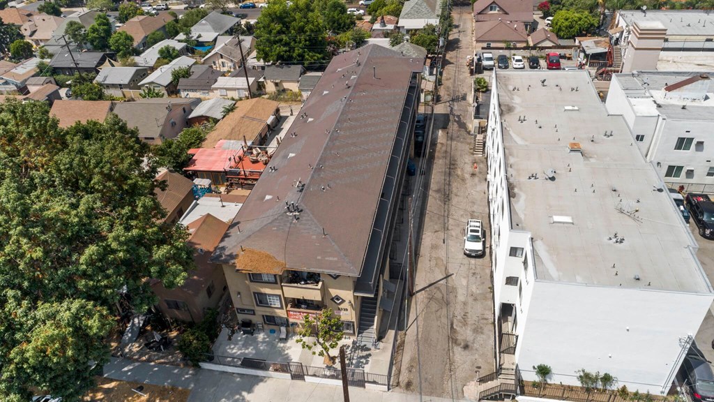 A parking lot is in front of a building with a brown roof.