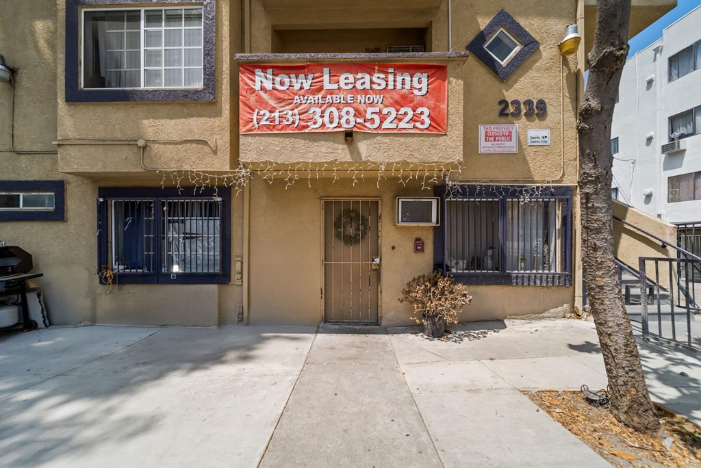 A building with a sign that says "Now Leasing" and a phone number.