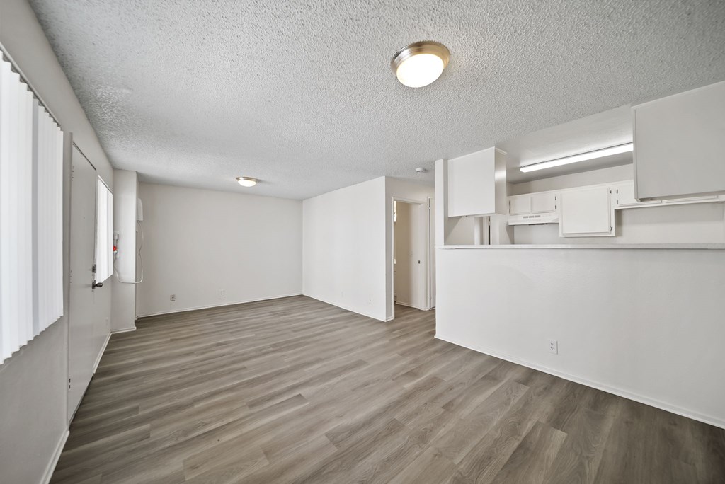 A room with a light brown floor and white walls.
