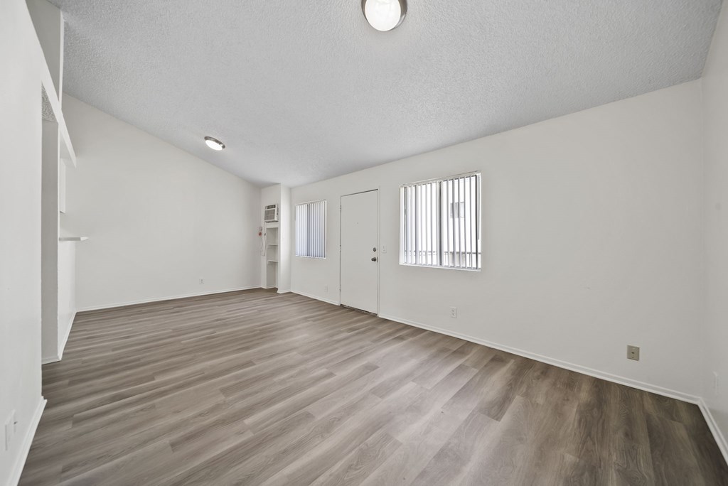 A room with wooden flooring and white walls.
