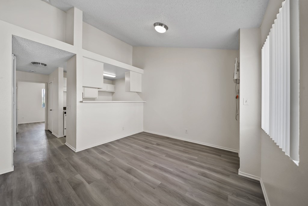 A room with wooden flooring and white walls.