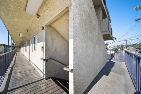 A long concrete building with a wooden walkway in front.
