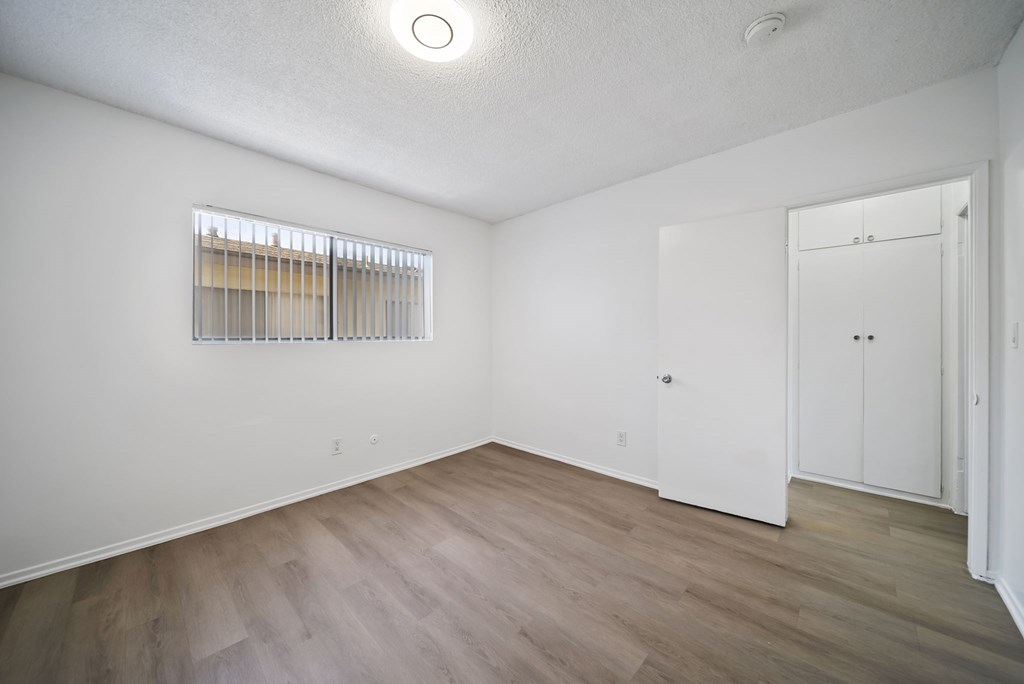 A room with a window and wooden flooring.