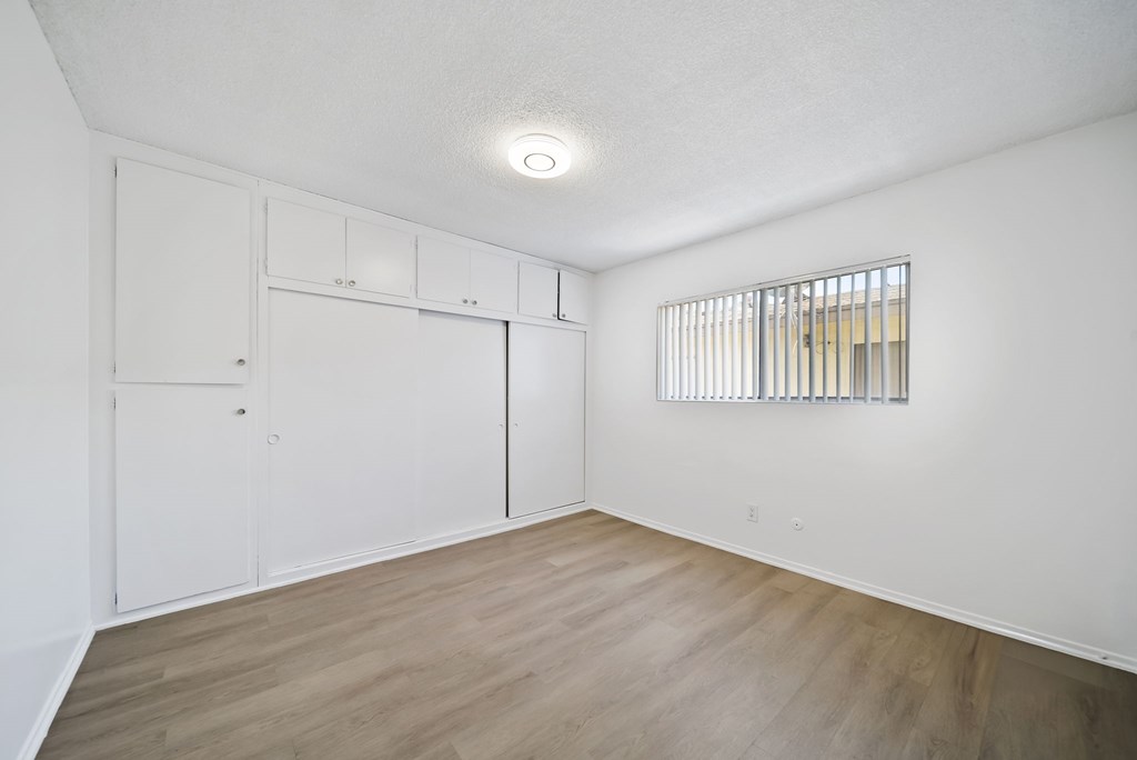 A room with a sliding door and a window with bars.