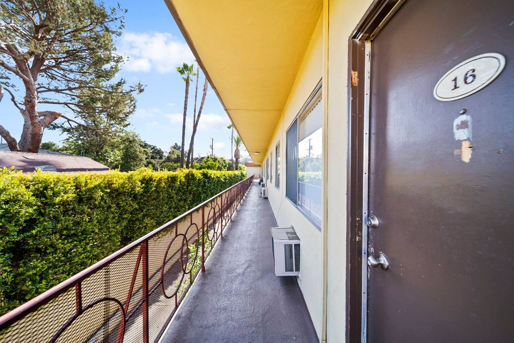 A long hallway with a door marked 16 on it.