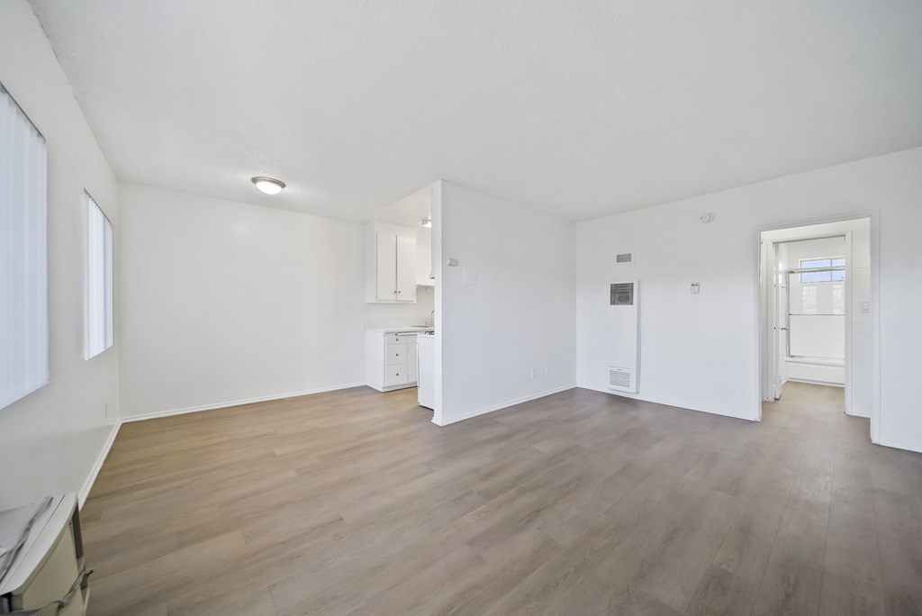 A large empty room with wooden floors and white walls.