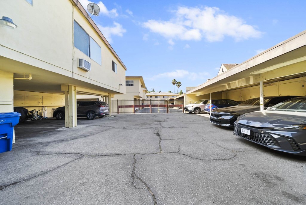 A parking lot with cars and a building in the background.