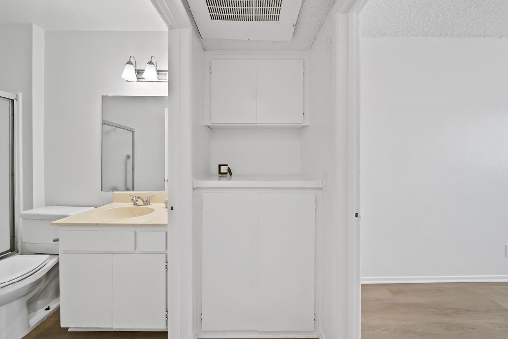 A white bathroom with a toilet, sink, and medicine cabinet.