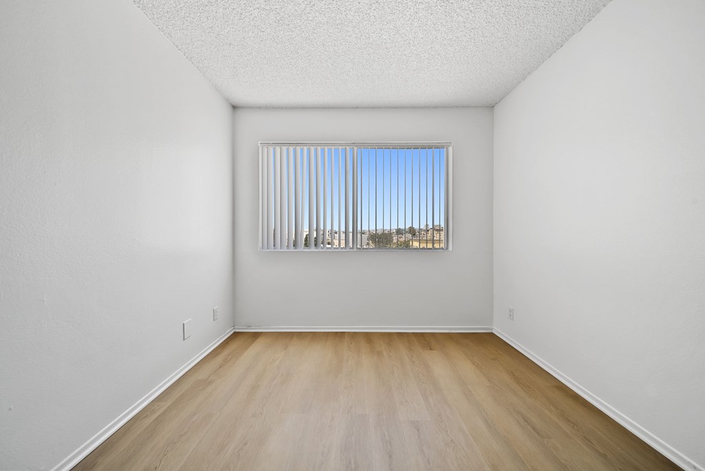 A room with a window and wooden floor.