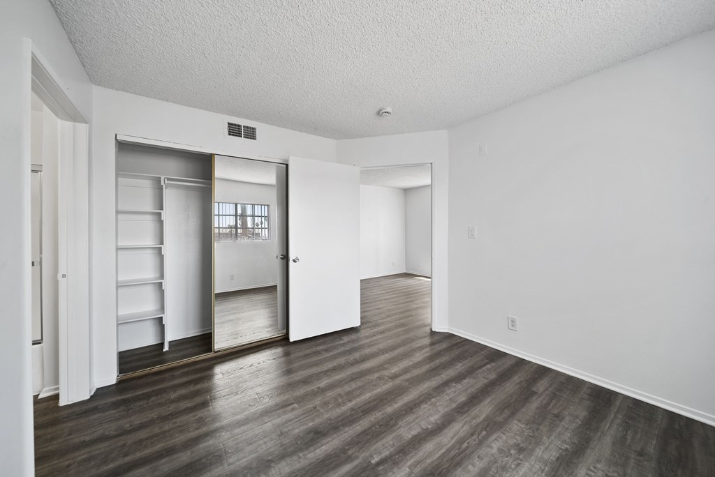 A room with a white wall and a wooden floor.