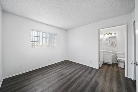 A room with a toilet, sink, and window.