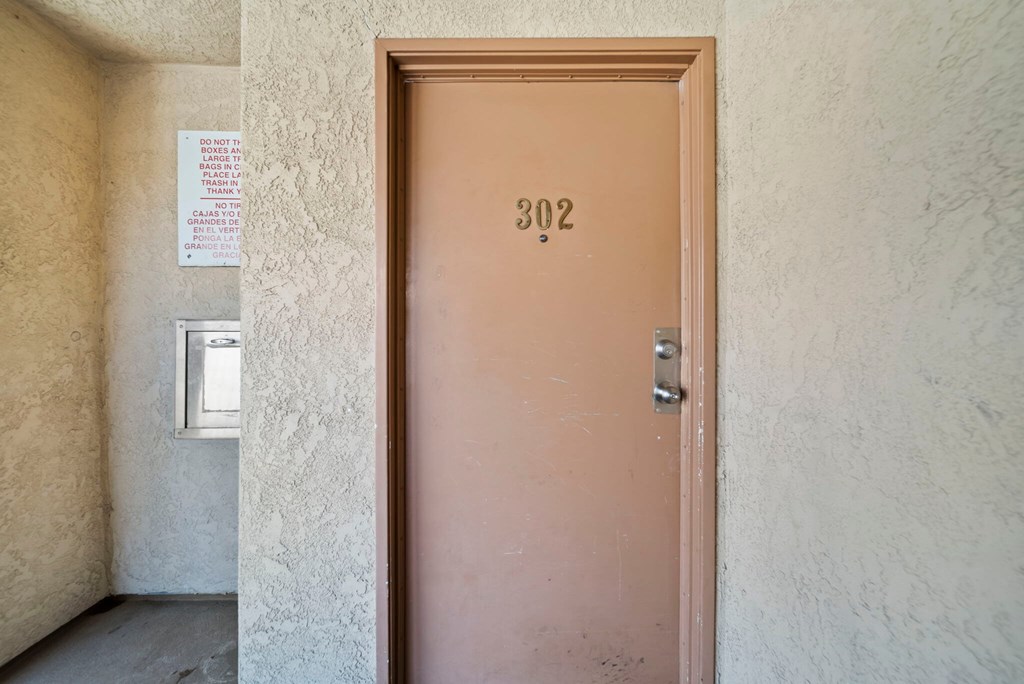 A brown door with the number 302 on it.