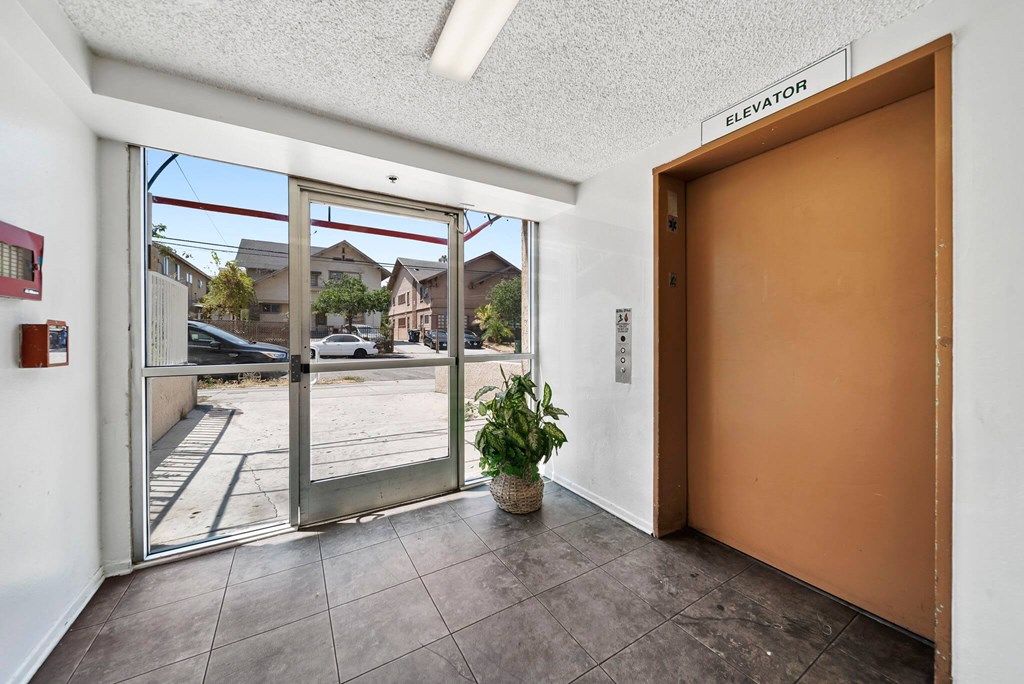 A brown door is on the right and a sign above it says elevator.