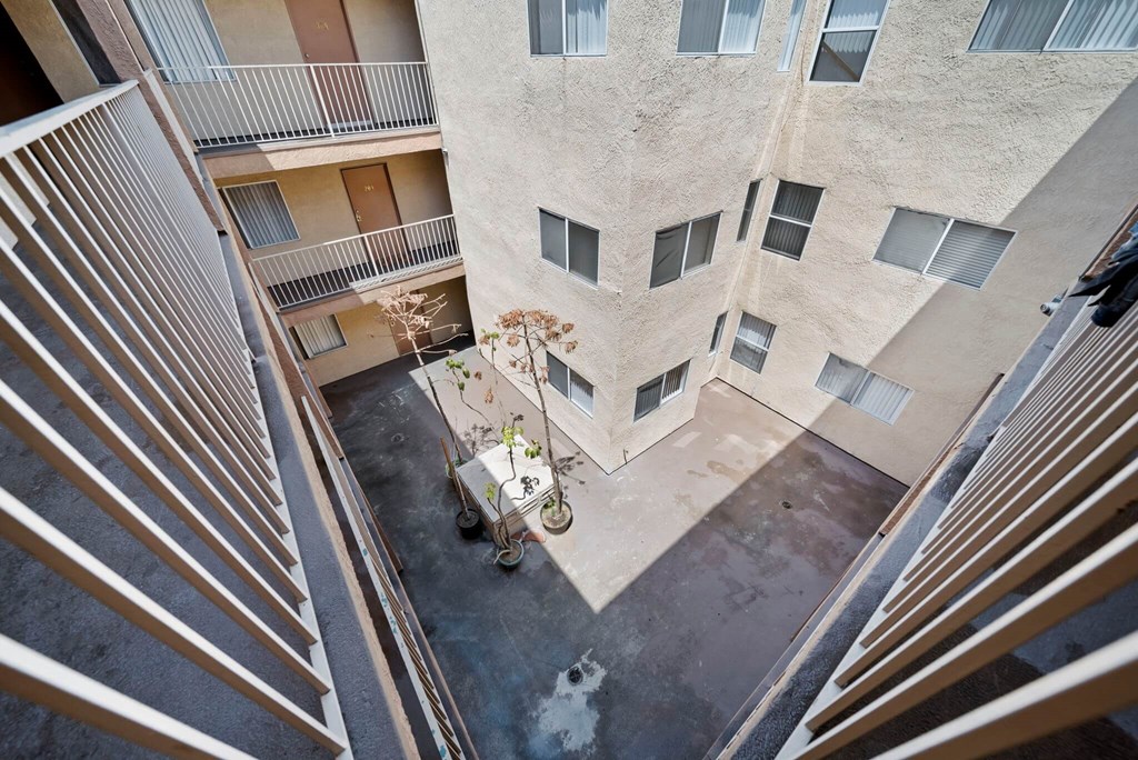 A balcony of a building with a potted plant on it.