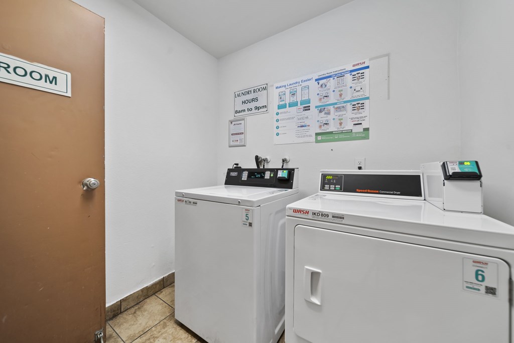 Laundry room with washing machines and a door.