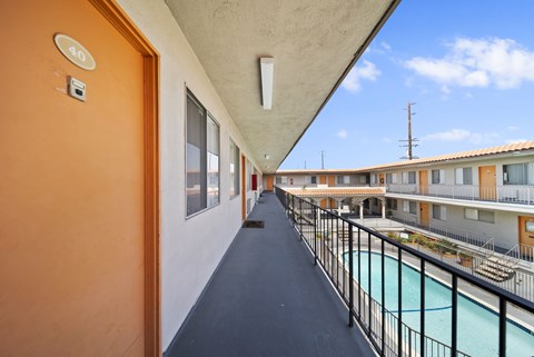 A balcony with a pool and a view of the sky.