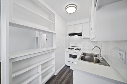 A small white kitchen with a sink and a stove.