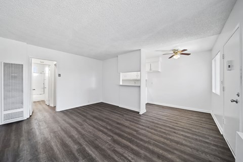 A room with a ceiling fan and a door leading to another room.