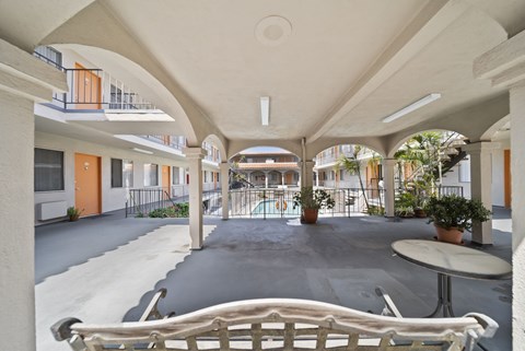 A white bench is in the middle of a courtyard.