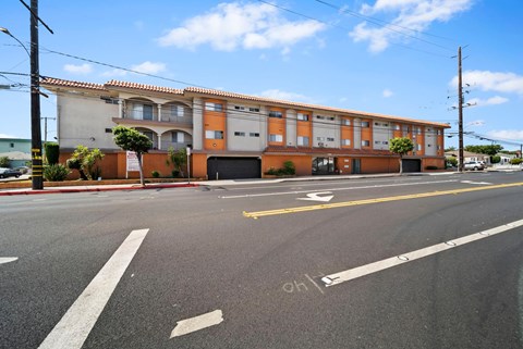 A street view of a building with a red and white striped curb.