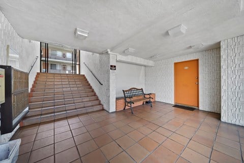 A hallway with a bench and a door.