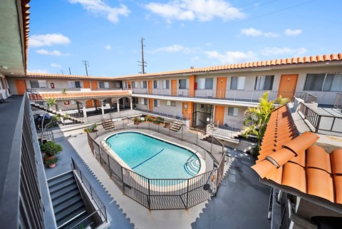 A pool in a courtyard surrounded by orange buildings.
