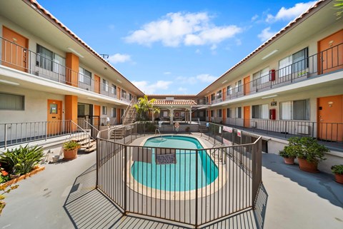 A pool surrounded by a fence in a courtyard.
