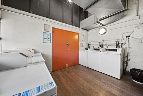 A room with a white printer and orange door.