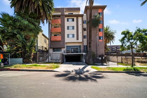 A multi-story building with a parking lot in front.