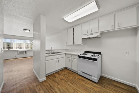 A kitchen with white cabinets and a stove top oven.
