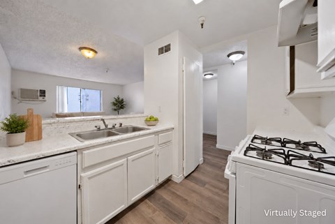 A kitchen with white cabinets and a stove top oven.