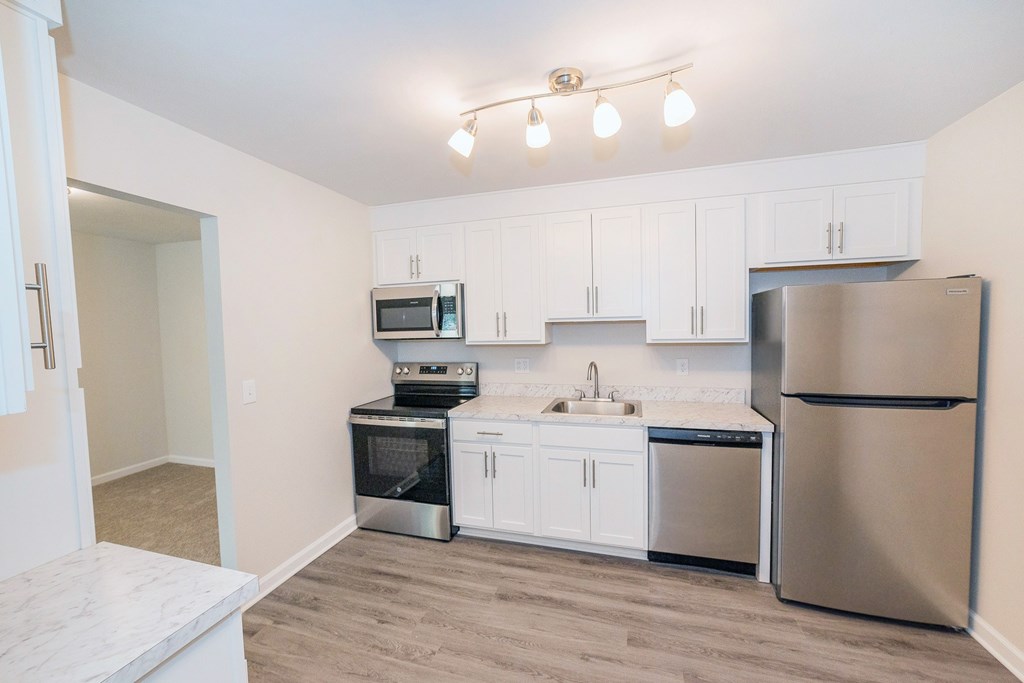 Fully renovated kitchen with white cabinets and stainless steel appliances.