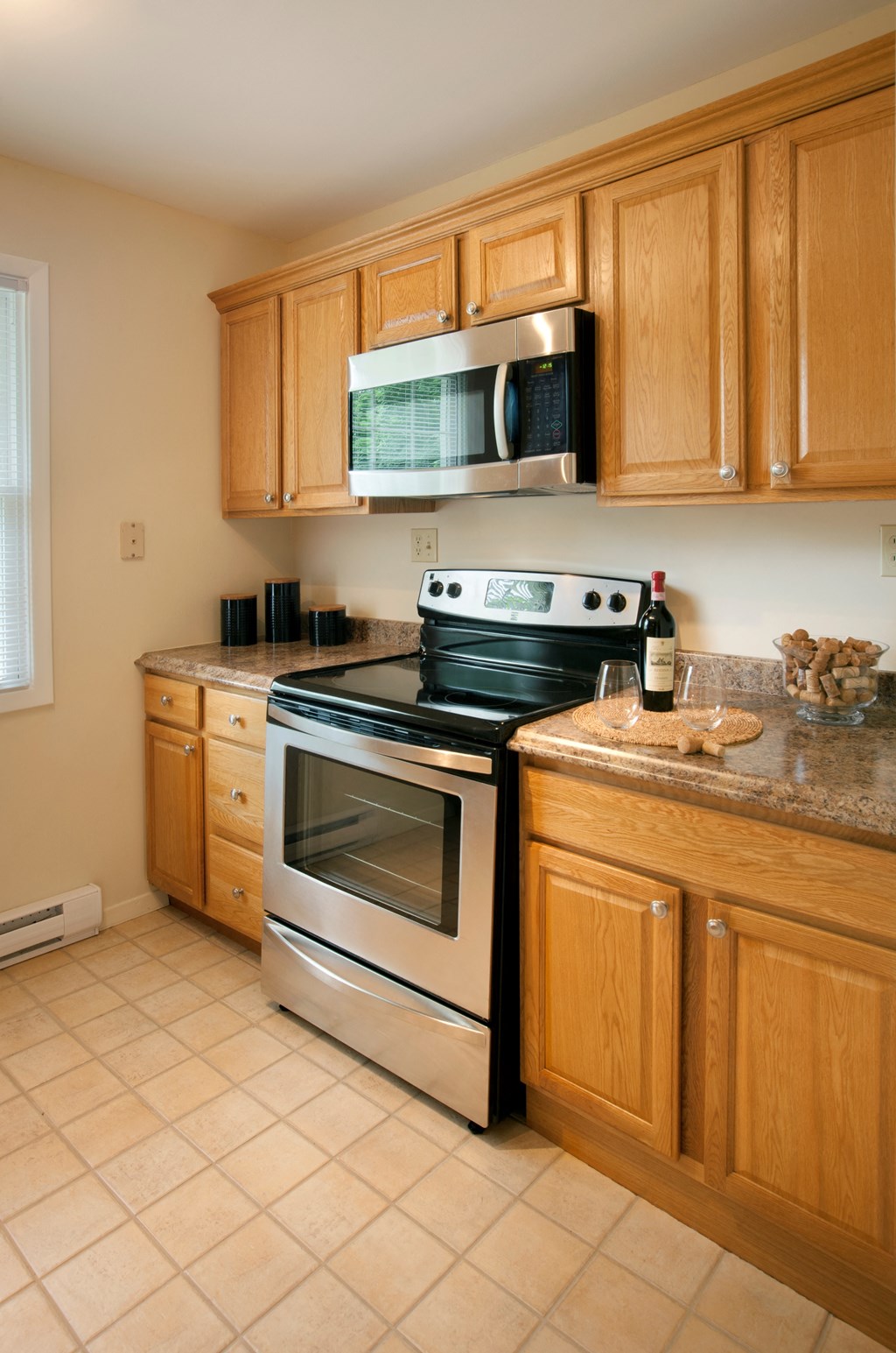 A kitchen with a stove top oven and microwave above it at Rivercrest Apartments, Piscataway , NJ