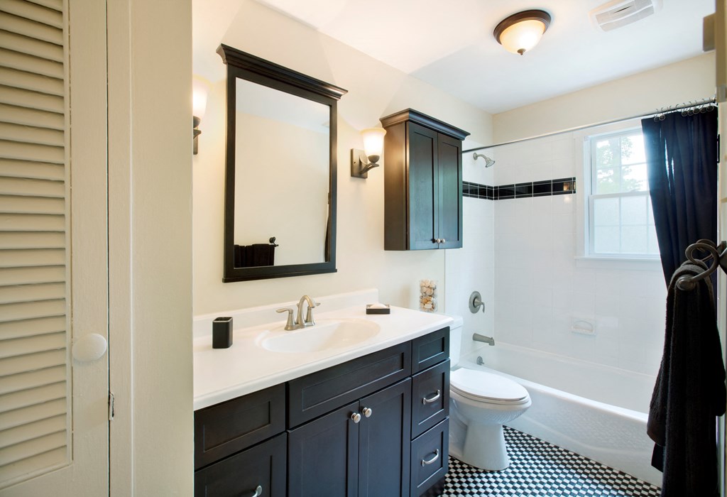 A bathroom with a black and white checkered floor. at Rivercrest Apartments, Piscataway