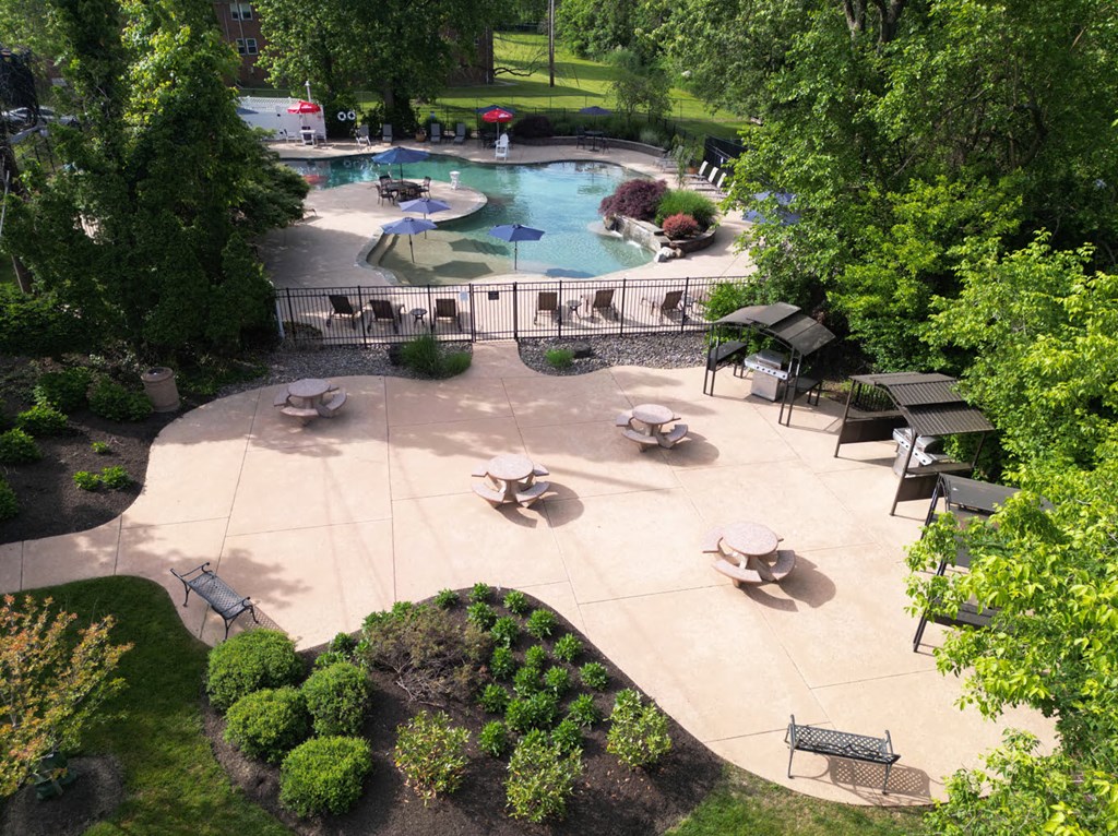 A pool surrounded by trees and a patio area at Rivercrest Apartments, New Jersey, 08854
