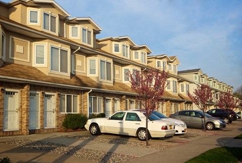 A white car is parked in front of a house. at Seaview Apartments in Staten Island, NY, 10305
