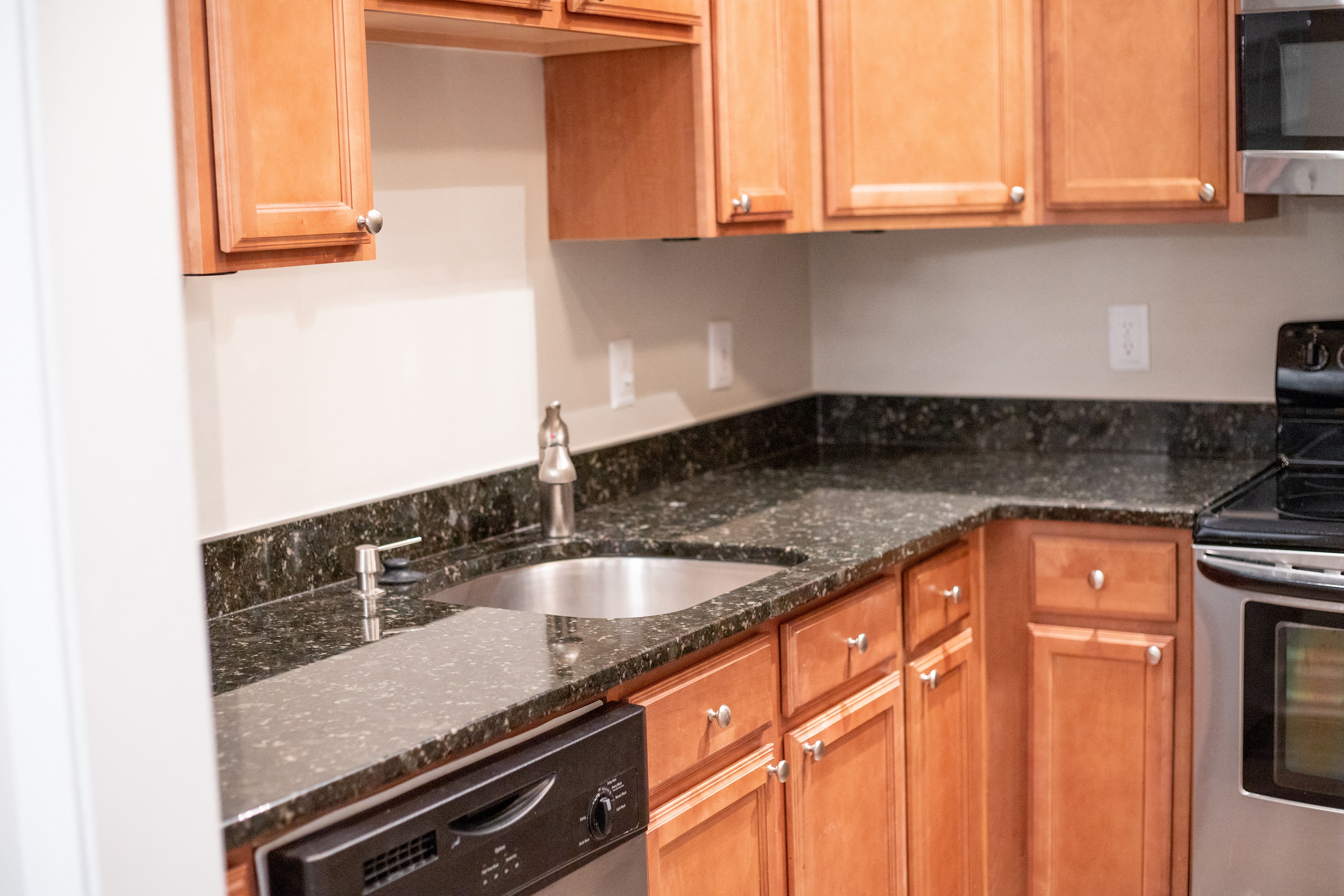 A kitchen with wooden cabinets and granite countertops.