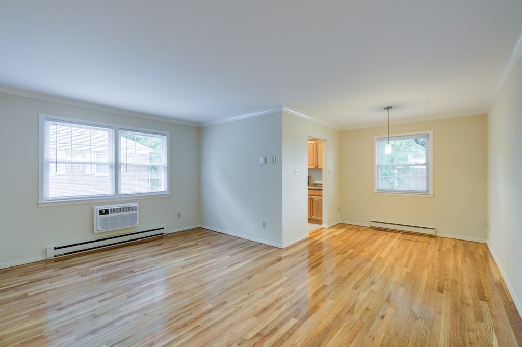 A room with wooden floors and two windows at Rivercrest Apartments, New Jersey, 08854