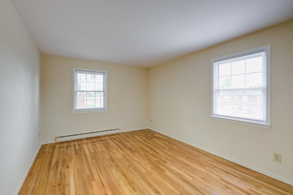 A room with wooden floors and two windows at Rivercrest Apartments, Piscataway , New Jersey