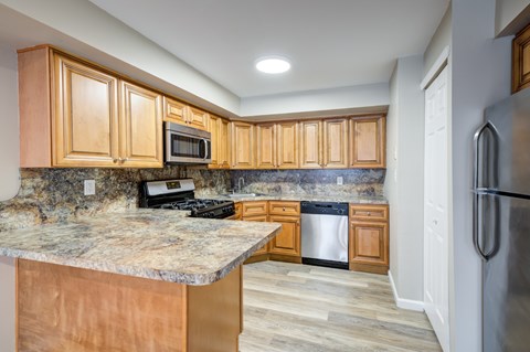 A kitchen with wooden cabinets and a granite countertop at Seaview Apartments in Staten Island, NY, 10305